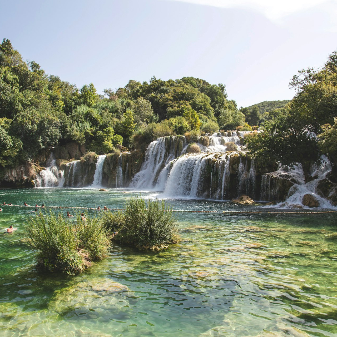 landscape photo of waterfalls flowing into river during daytime